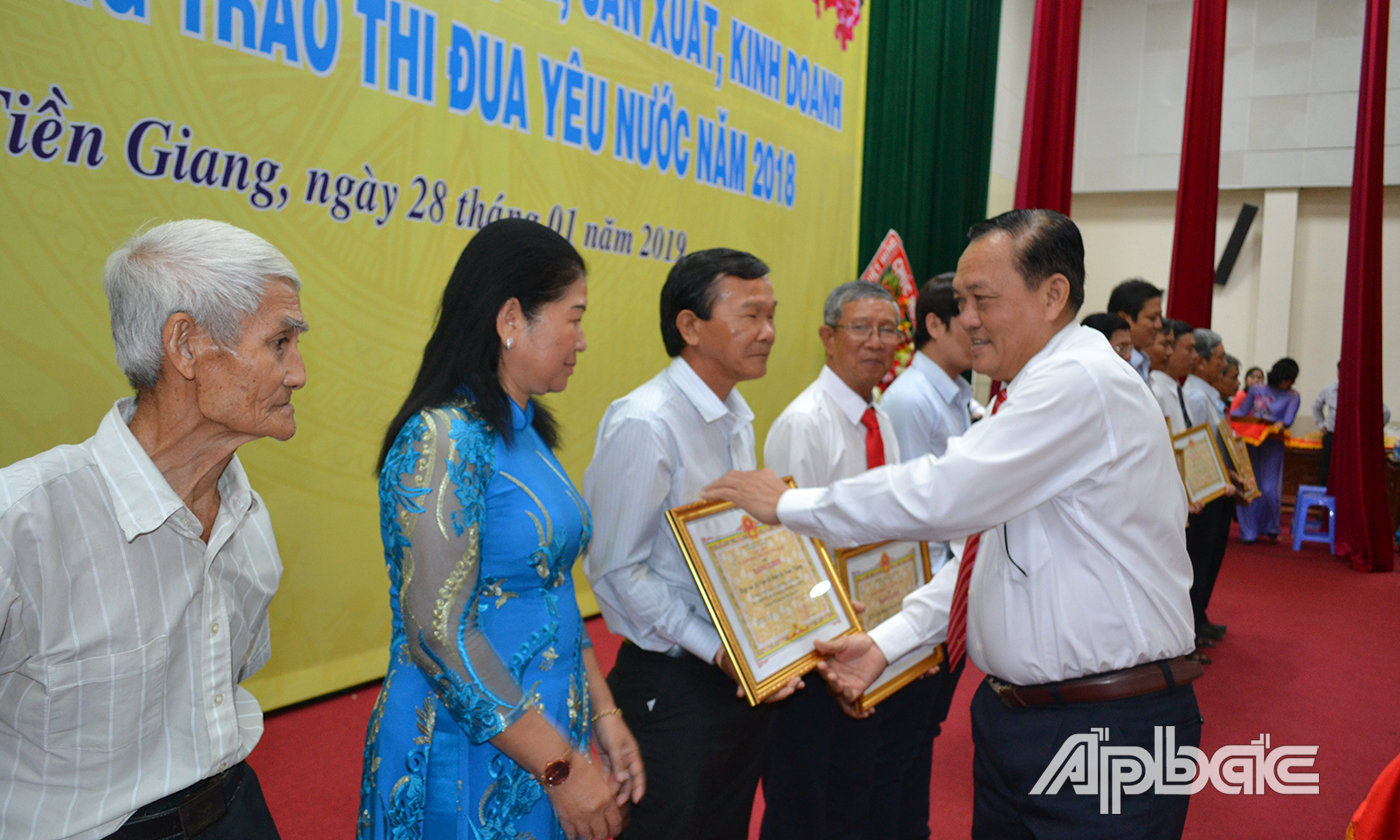 Lãnh đạo HTX (bìa trái) nhận Bằng khen của UBND tỉnh. 						Ảnh: THU HOÀI