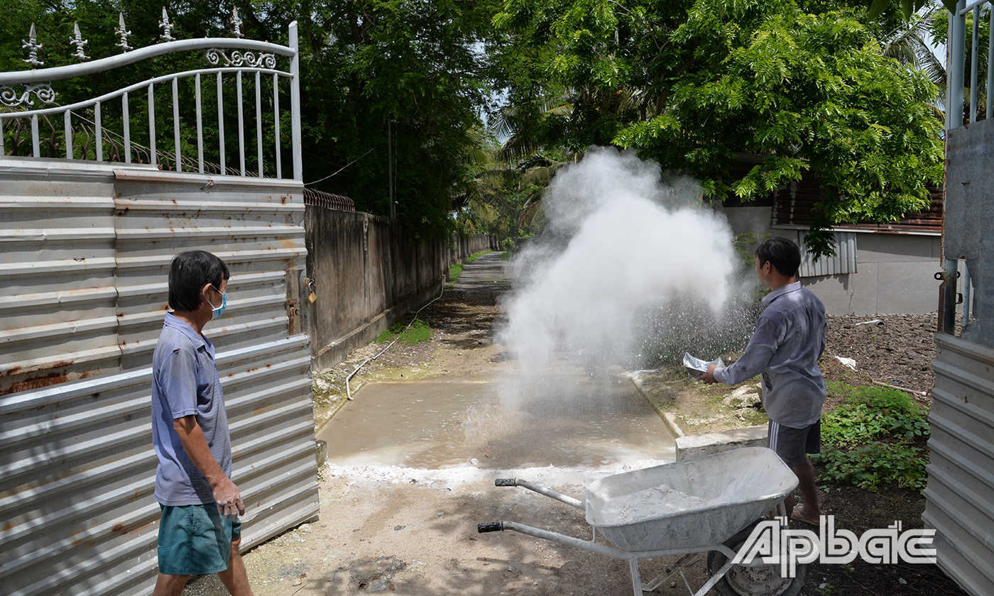 Vôi được rải trong hố sau cửa trang trại của ông Bá.