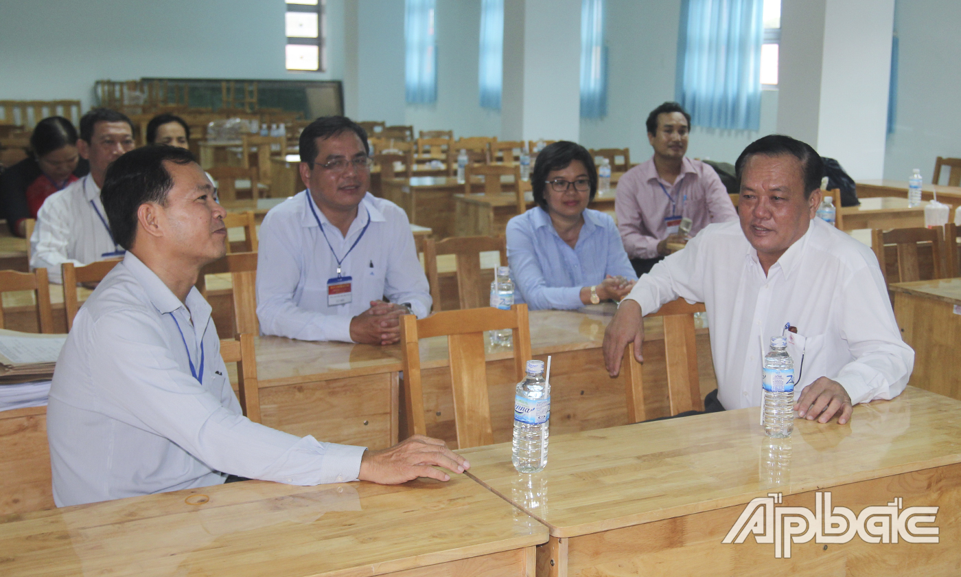 Điểm thi Trường THPT Trần Văn Hoài (bìa trái) báo cáo nhanh tình hình buổi thi đầu tiên với đoàn công tác.