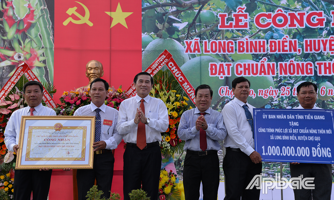 Đồng chí Lê Văn Hưởng và đồng chí Nguyễn Ngọc Trầm trao Bằng công nhận và Bảng tượng trưng công trình phúc lợi trị giá 1 tỷ đồng cho lãnh đạo  xã Long Bình Điền.