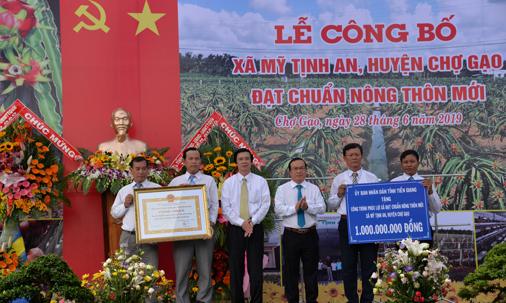 Đồng chí Nguyễn Văn Danh và đồng chí Phạm Anh Tuấn trao Bằng công nhận và công trình phúc lợi 1 tỷ đồng cho đại diện xã Mỹ Tịnh An.