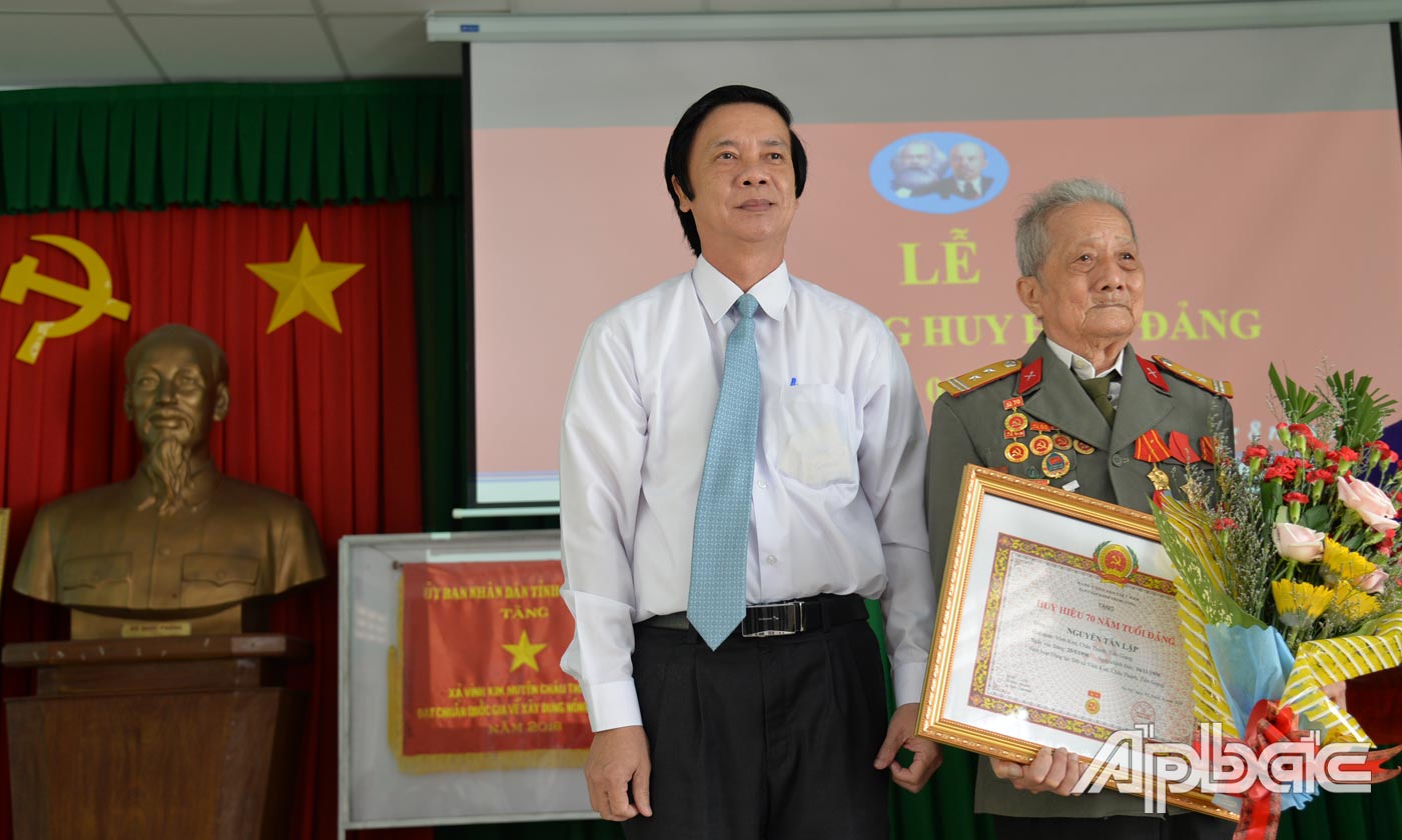 Đồng chí Nguyễn Văn Danh gắn Huy hiệu 70 năm tuổi Đảng và tặng quà cho đảng viên Nguyễn Tấn Lập