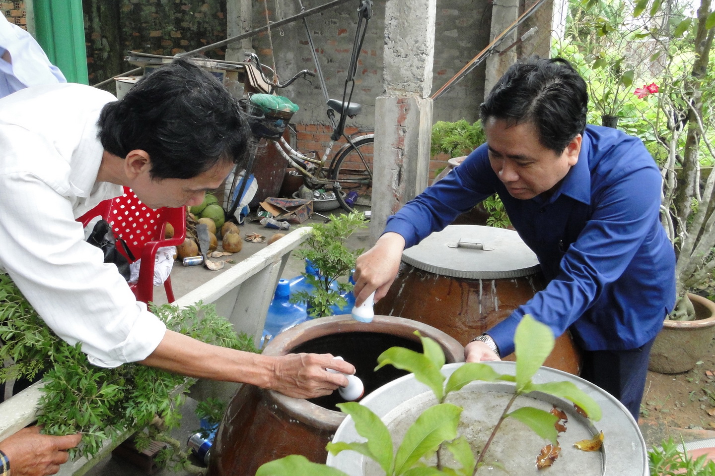 Phó Chủ tịch UBND tỉnh Trần Văn Dũng kiểm tra chỉ số lăng quăng trong dụng cụ chứa nước tại hộ dân ở xã Phước Lập