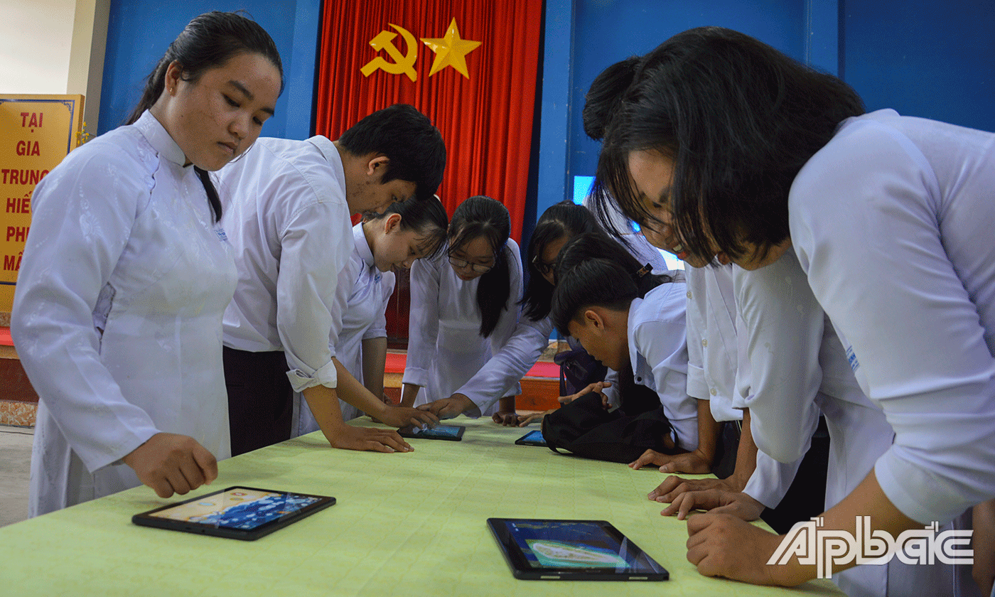 Học sinh được tham quan triển lãm và trải nghiệm các ứng dụng công nghệ thông tin trên máy tính bảng. 