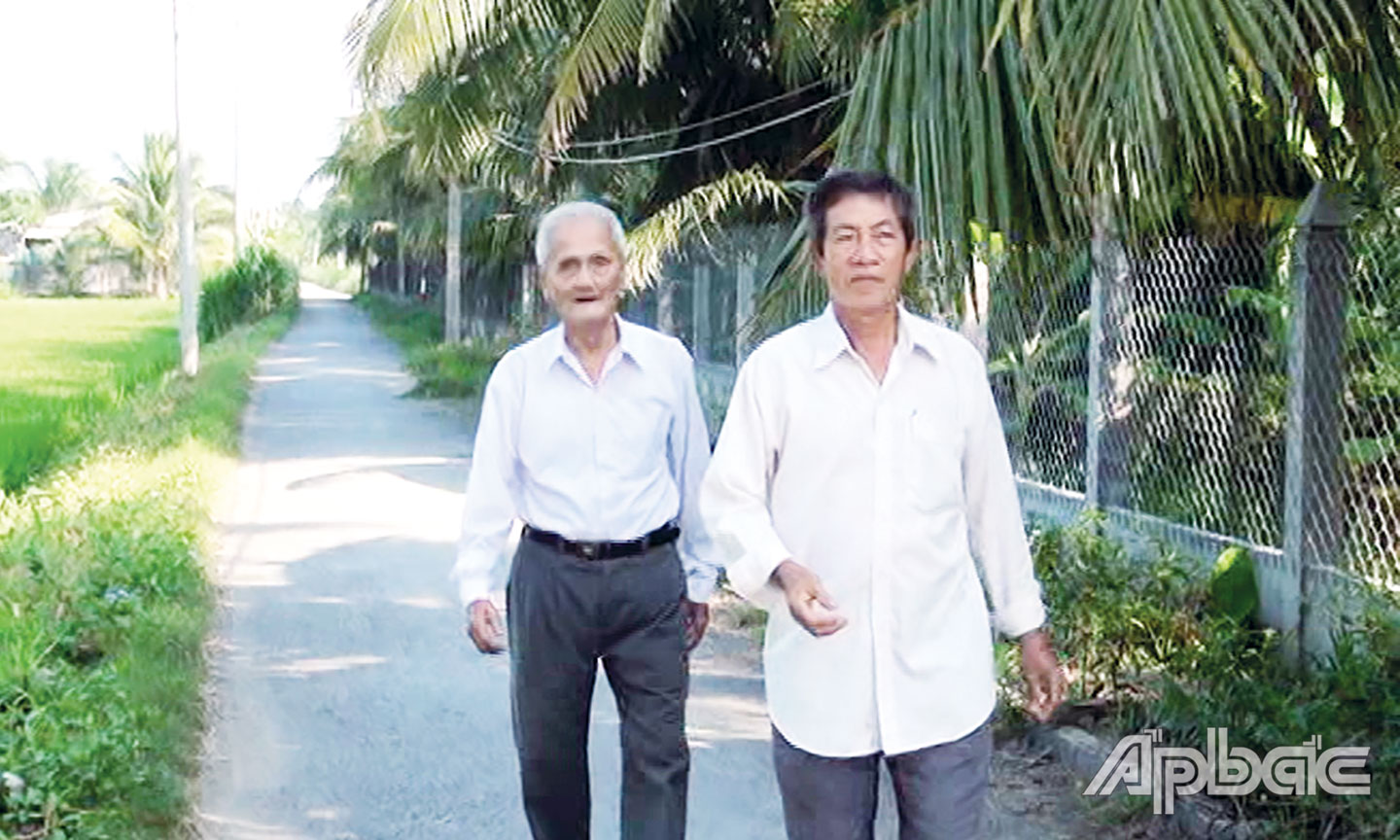Ông Công (bên trái) đi trên con đường “Ba Kỉnh” mà ông đã đóng góp  để xây dựng khang trang, sạch đẹp.  