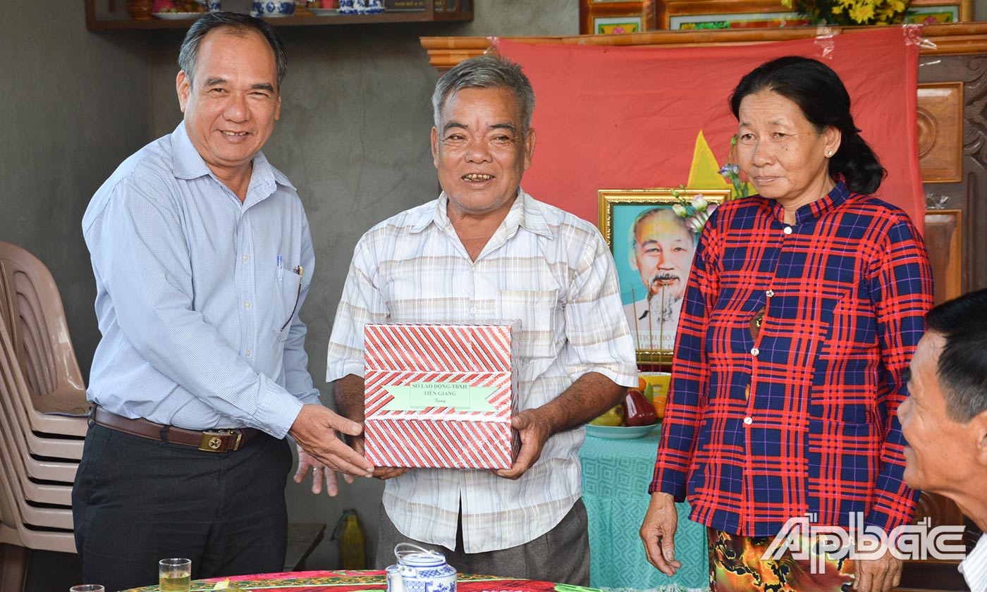 Đồng chí Phan Thanh Vân, Phó Giám đốc Sở Lao động - Thương binh và Xã hội trao quà cho gia đình ông Nguyễn Văn Nhịn.