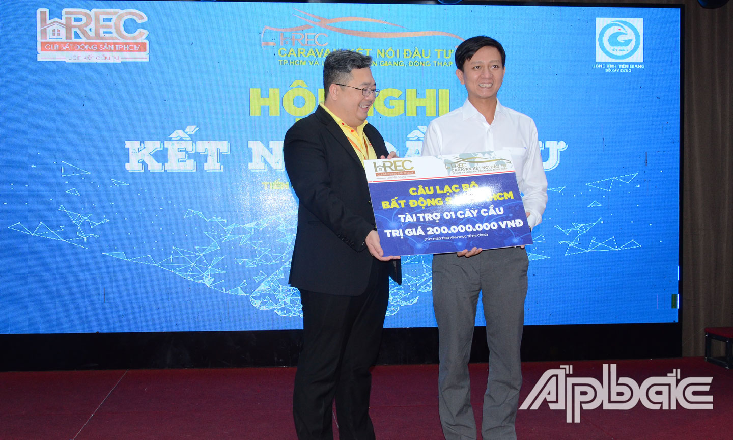 Đại diện HREC trao bảng biểu trưng trị giá 200 triệu đồng để xây dựng 1 cây cầu giao thông nông thôn cho lãnh đạo Sở Giao thông - Vận tải.