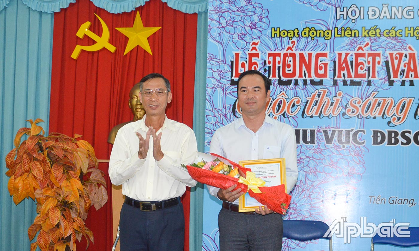 Đồng chí Phan Thanh Dũng, Phó Ban Tuyên giáo Tỉnh ủy Tiền Giang trao giải Nhất cho tác giả Hoàng Chương.