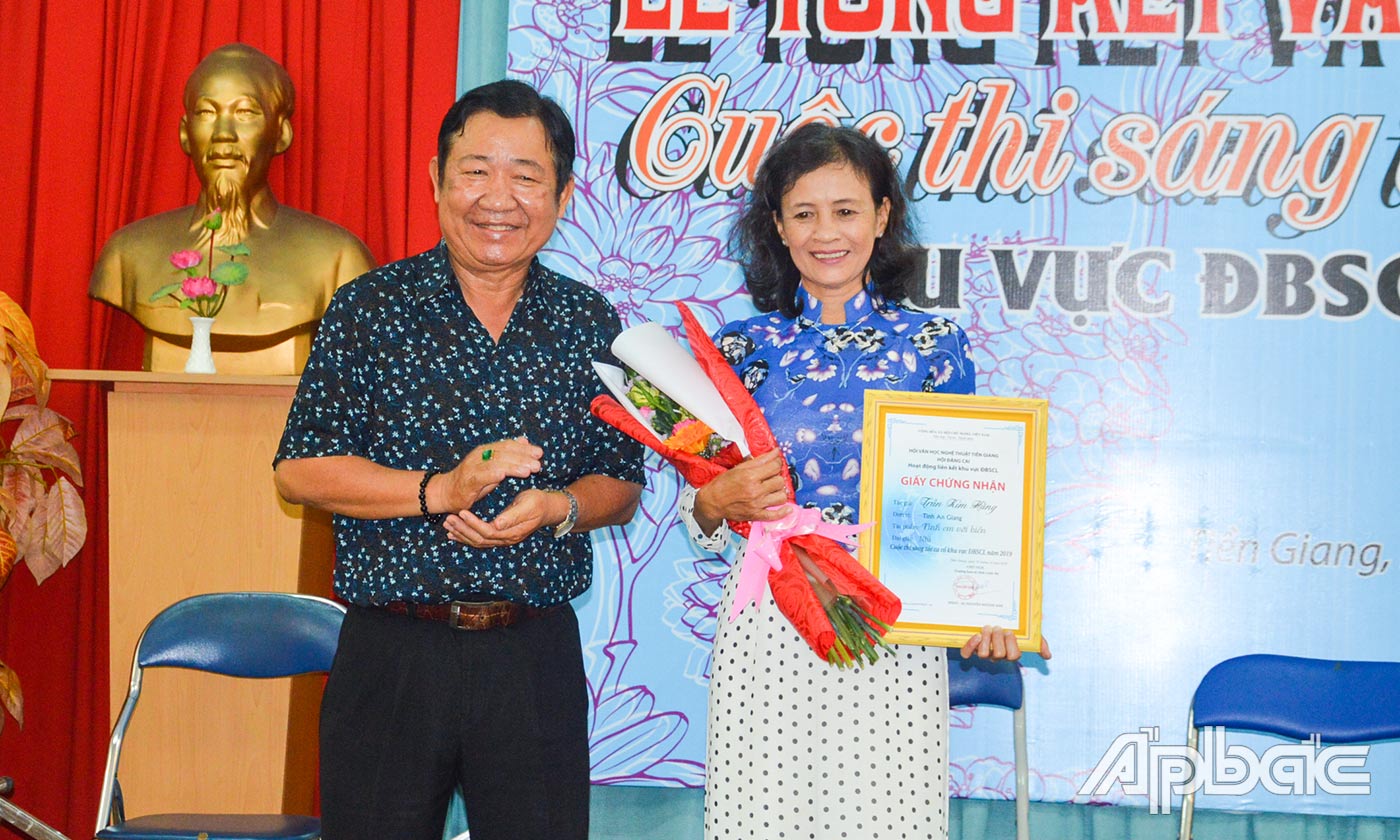 Nghệ nhân Ưu tú - Soạn giả Nguyễn Huỳnh Anh, Chủ tịch Hội Văn học - Nghệ thuật Tiền Giang trao giải Nhì cho tác giả Kim Hằng (tỉnh An Giang).