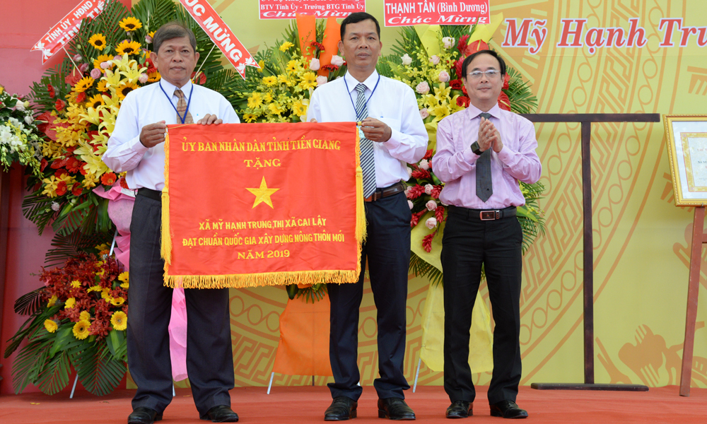 Đồng chí Trần Kim Trát, Tỉnh ủy viên, Bí thư Thị ủy TX. Cai Lậy trao cờ thi đua của UBND tỉnh Tiền Giang cho Đảng bộ, chính quyền và nhân dân xã Mỹ Hạnh Trung.