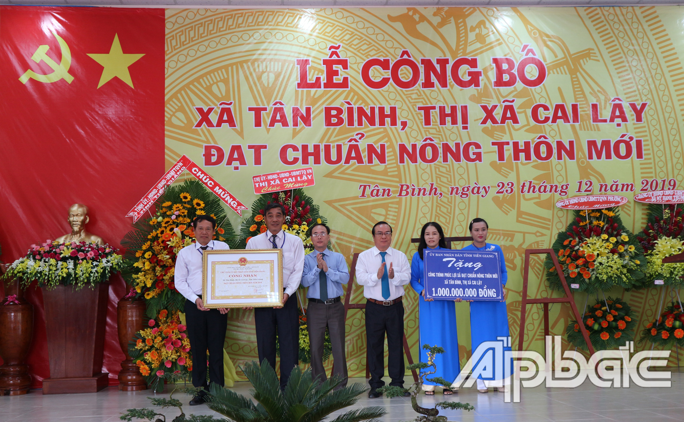 Đồng chí Trần Kim Trát và đồng chí Phạm Anh Tuấn trao Bằng công nhận xã đạt chuẩn NTM và Bảng tượng trưng tặng công trình phúc lợi 1 tỷ đồng cho xã Tân Bình
