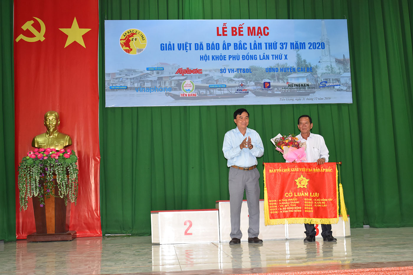Đại diện lãnh đạo Ủy ban nhân dân huyện Gò Công Tây trao Cờ luân lưu cho Ủy ban nhân dân huyện Cai Lậy - đơn vị đăng cai Giải Việt dã Báo Ấp Bắc lần thứ 38 - năm 2020