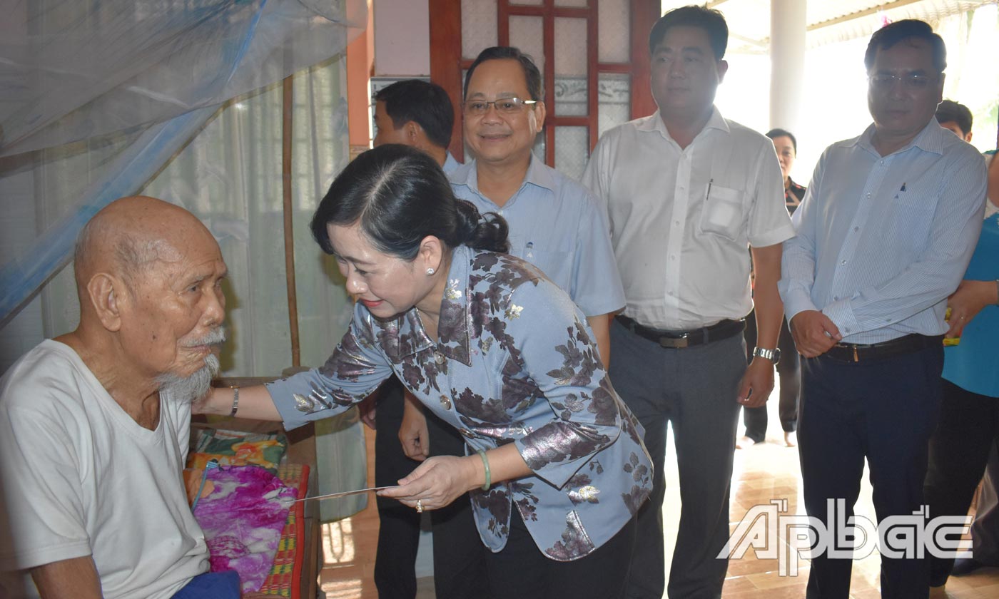 Đồng chí Châu Thị Mỹ Phương ân cần thăm hỏi sức khỏe và tặng quà cho ông Lê Văn Hớn (cán bộ bị bắt tù đày) của xã Bình Ninh.