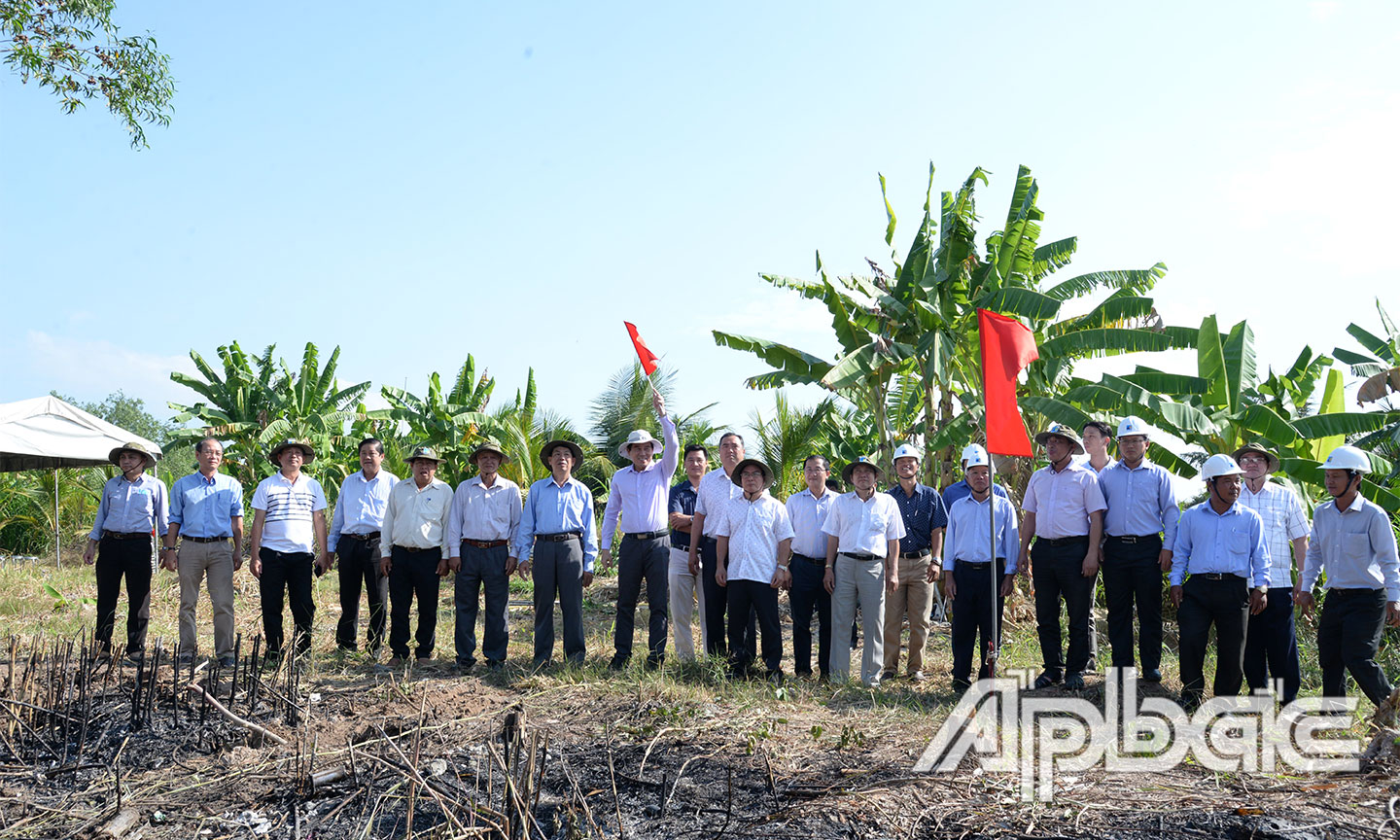 Đồng chí Lê Văn Hưởng phất cờ để khởi động đóng những cột thép đầu tiên.