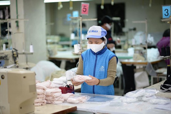 Công nhân tại Công ty Dệt kim Đông Xuân đang phải thay ca, làm ngày làm đêm để đạt đủ công suất 60.000 chiếc khẩu trang/ngày kể từ 7-2, và sẽ phấn đấu nâng lên 200.000 chiếc/ngày kể từ 10-2, để đáp ứng nhu cầu mua khẩu trang giá bình ổn của người dân cả nước. Ảnh theo Vinatex