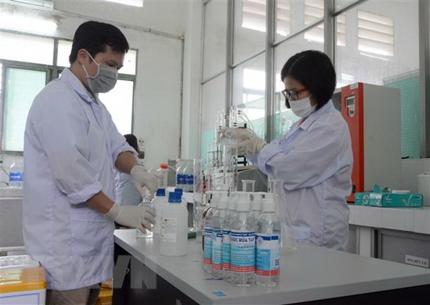Cán bộ, giảng viên trường Đại học Sư phạm Kỹ thuật-Đại học Đà Nẵng pha chế nước rửa tay sát khuẩn. (Ảnh: Văn Dũng/TTXVN)