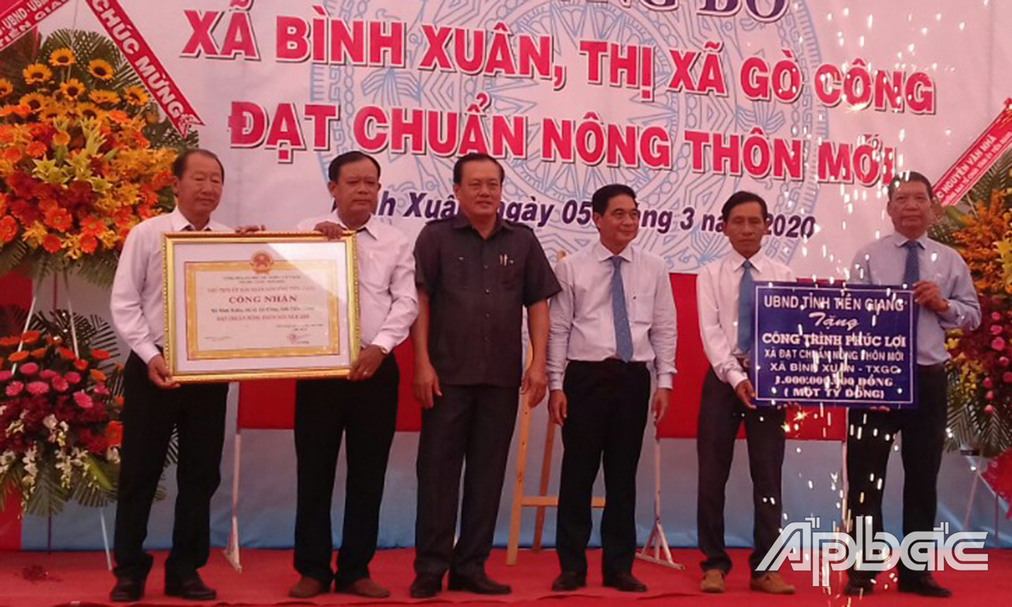 Đồng chí Nguyễn Văn Nhã và đồng chí Lê Văn Nghĩa trao Bằng công nhận đạt chuẩn NTM và Bảng tượng trưng tặng công trình phúc lợi trị giá 1 tỷ đồng cho xã Bình Xuân. 