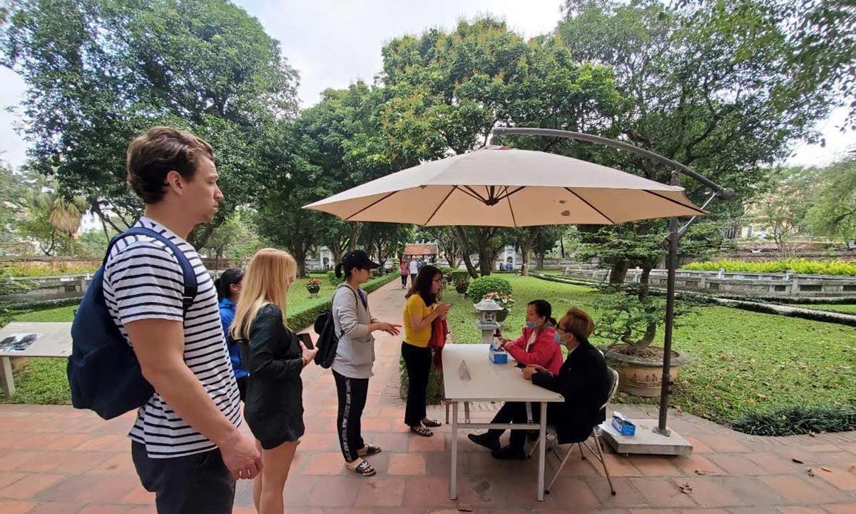 Du khách quốc tế thăm quan Văn Miếu trước ngày điểm đến này đóng cửa phòng dịch. (Ảnh: Bùi Huy Hoàng/Vietnam+)