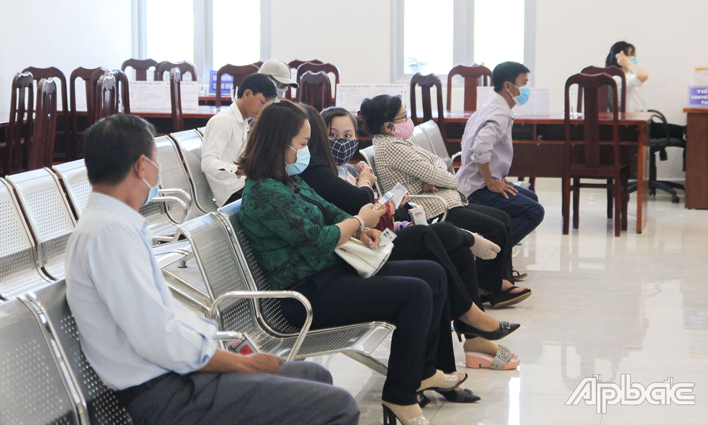 Người dân chấp hành việc đeo khẩu trang khi đến làm thủ tục tại Trung tâm Phục vụ hành chính công tỉnh.