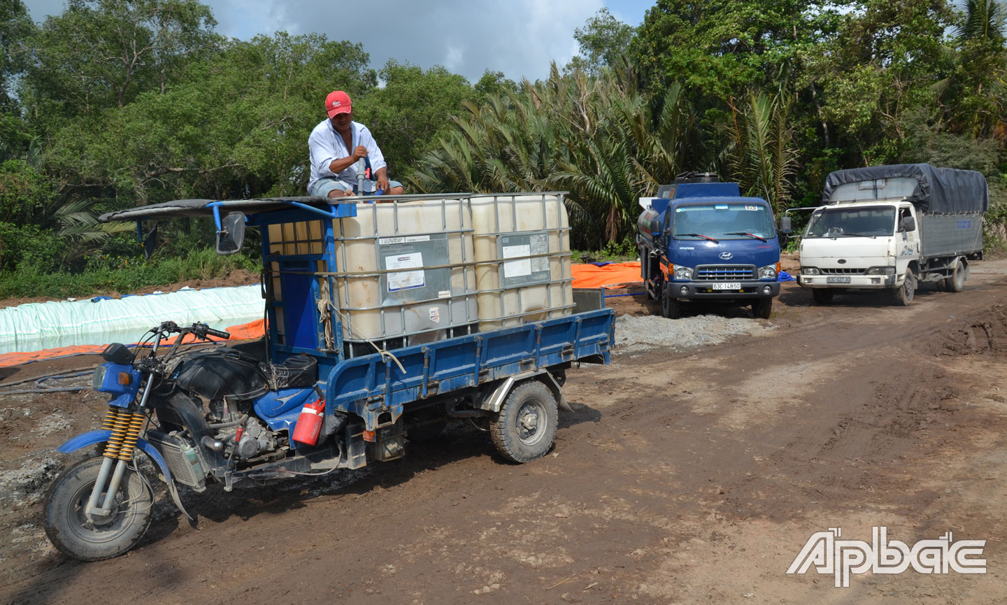 Anh Võ Minh Ngọc đến điểm cấp nước ngọt tại xã Bình Phan, huyện Chợ Gạo về để tưới cho vườn thanh long.