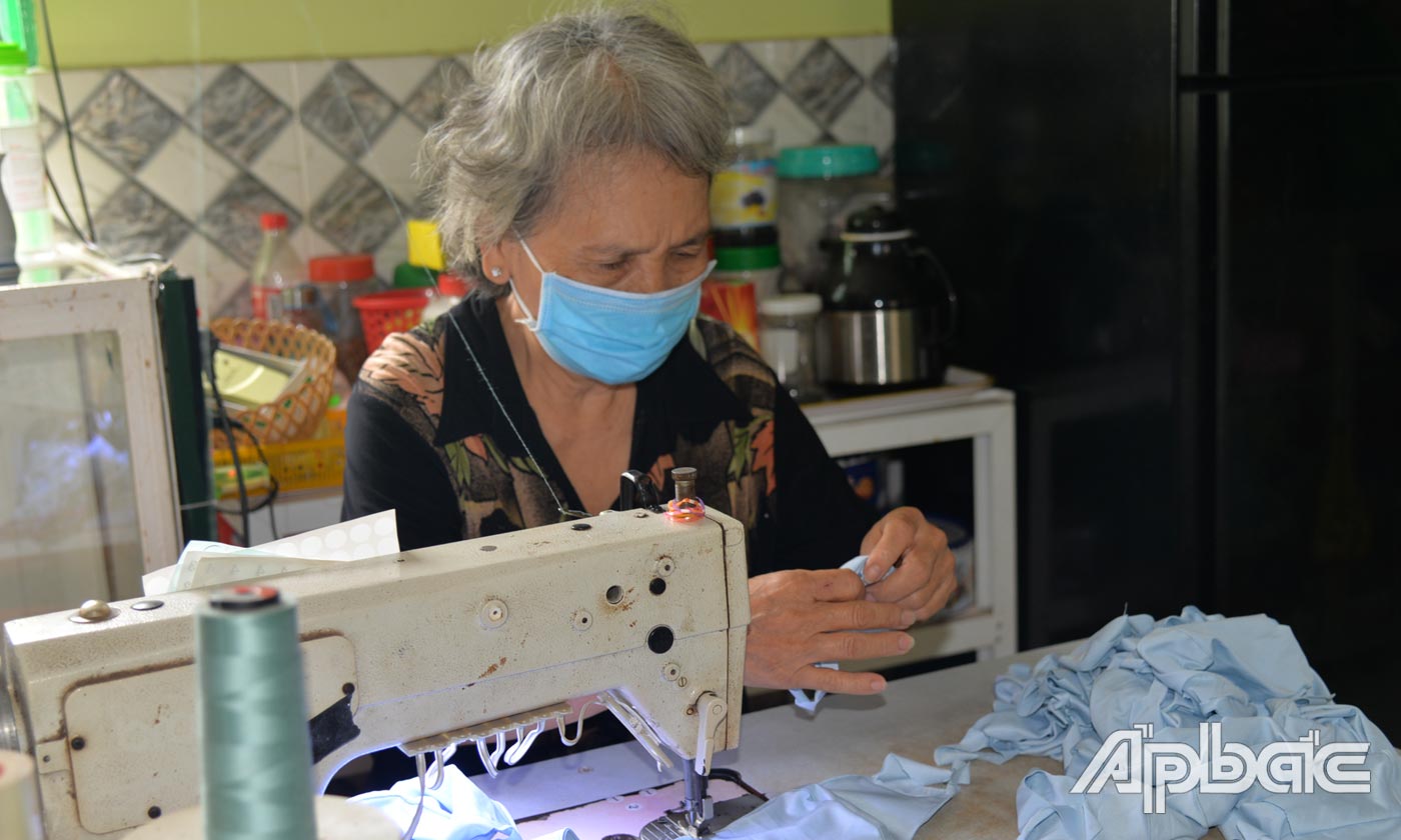 Chị em phụ nữ nhận khẩu trang về nhà may.