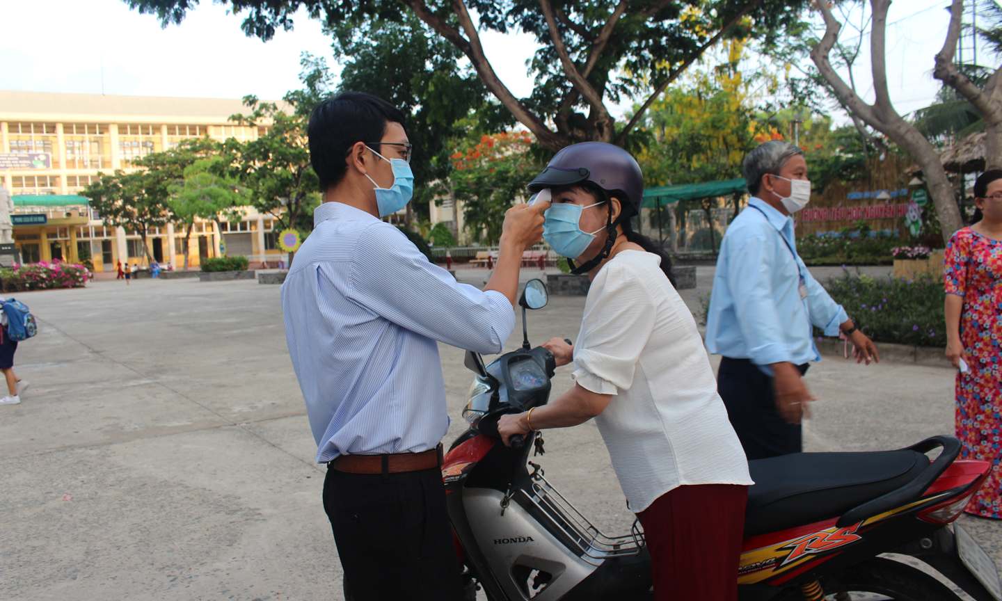 Đo thân nhiệt cho giáo viên.