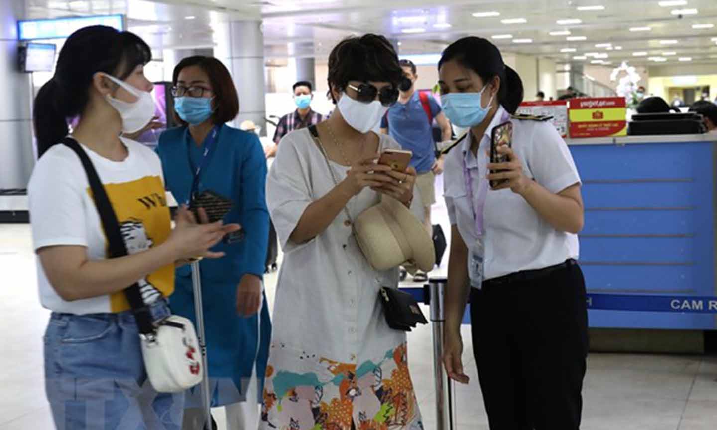 Nhân viên mặt đất kiểm tra mã khai báo y tế hành khách tại sân bay. (Ảnh: Ngọc Hà/TTXVN)