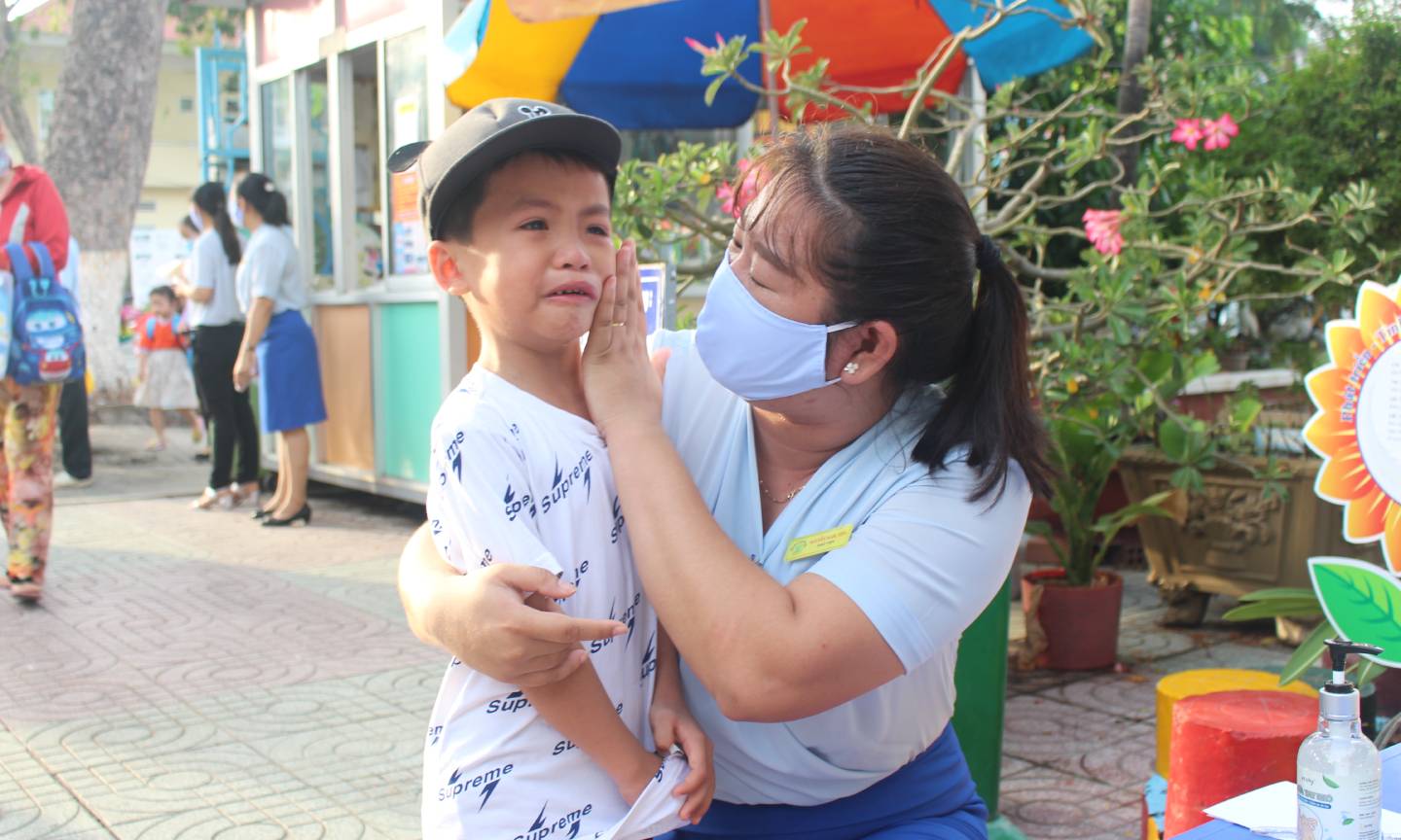Cô dỗ dành khi trẻ khóc nhòe.