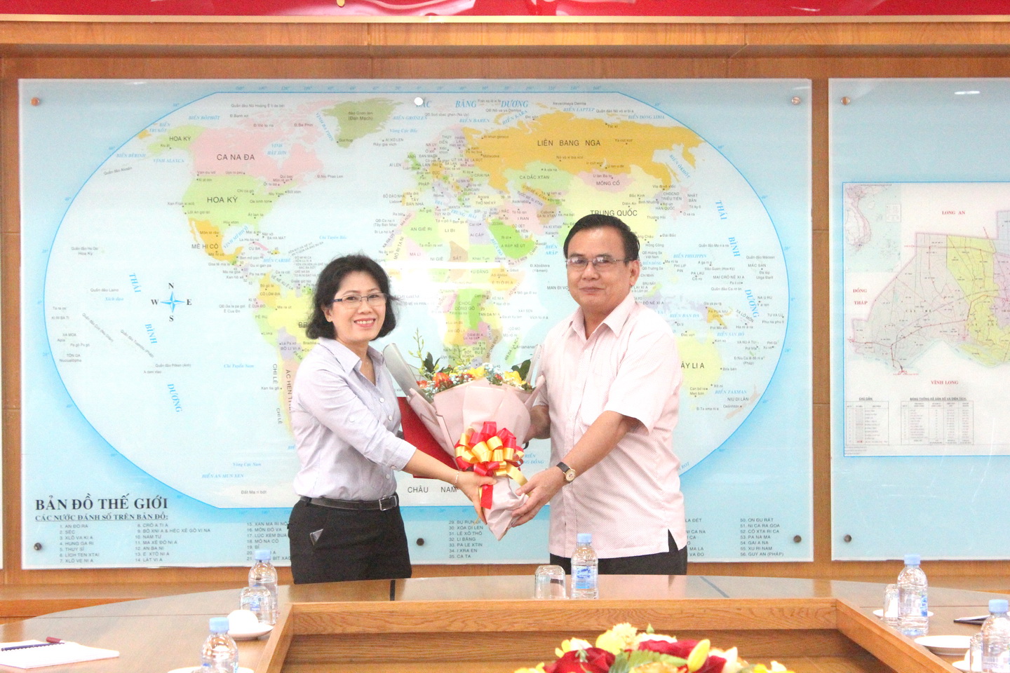Đồng chí Võ Văn Bình, Phó Bí thư Thường trực Tỉnh ủy trao quyết định bổ nhiệm và hoa chúc mừng đồng chí Phạm Thị Mai Tiên giữ nhiệm vụ công tác mới. Ảnh: PHẠN QUỐC HƯNG