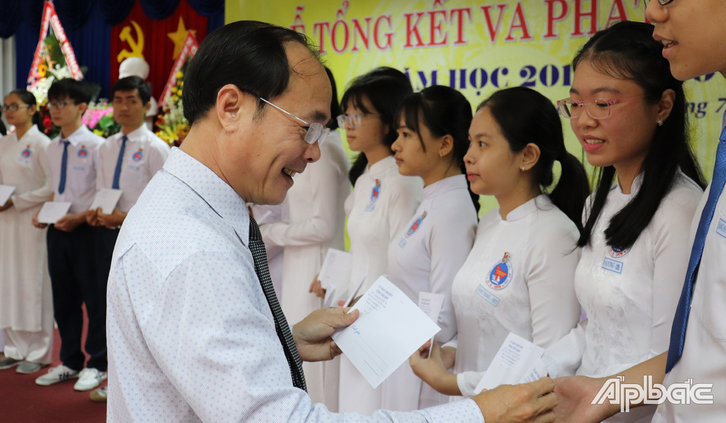 Đồng chí Trần Kim Trát trao học bổng cho học sinh.