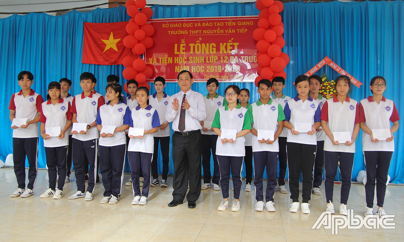 Đồng chí Nguyễn Văn Vĩnh  trao học bổng cho các em học sinh. 