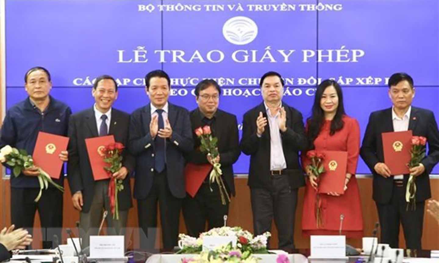 Phó trưởng Ban Tuyên giáo Trung ương Lê Mạnh Hùng và Thứ trưởng Bộ Thông tin và Truyền thông Hoàng Vĩnh Bảo trao giấy phép cho 18 tạp chí thực hiện chuyển đổi, sắp xếp lại theo quy hoạch báo chí. (Ảnh: Minh Quyết/TTXVN)