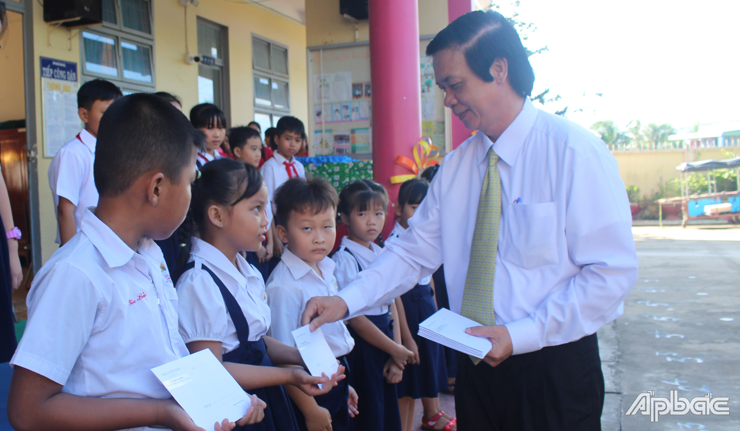 Đồng chí Nguyễn Văn Danh trao học bổng cho học sinh. 