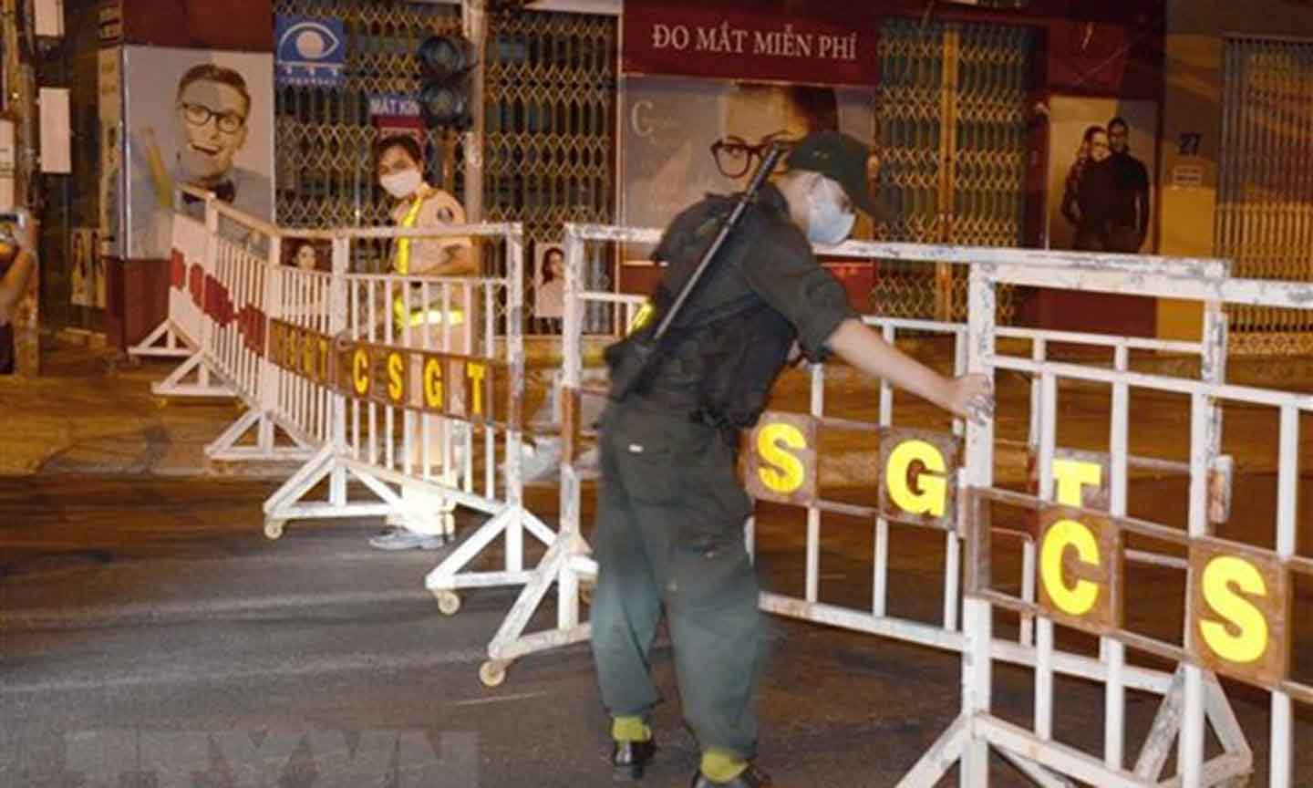 Lực lượng chức năng lập hàng rào phong tỏa và chốt chặn khu vực bị cách ly. (Ảnh: Quốc Dũng/TTXVN)