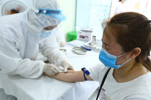 Nhân viên y tế lấy mẫu xét nghiệm nhanh cho người về từ Đà Nẵng. (Ảnh: Minh Quyết/TTXVN)