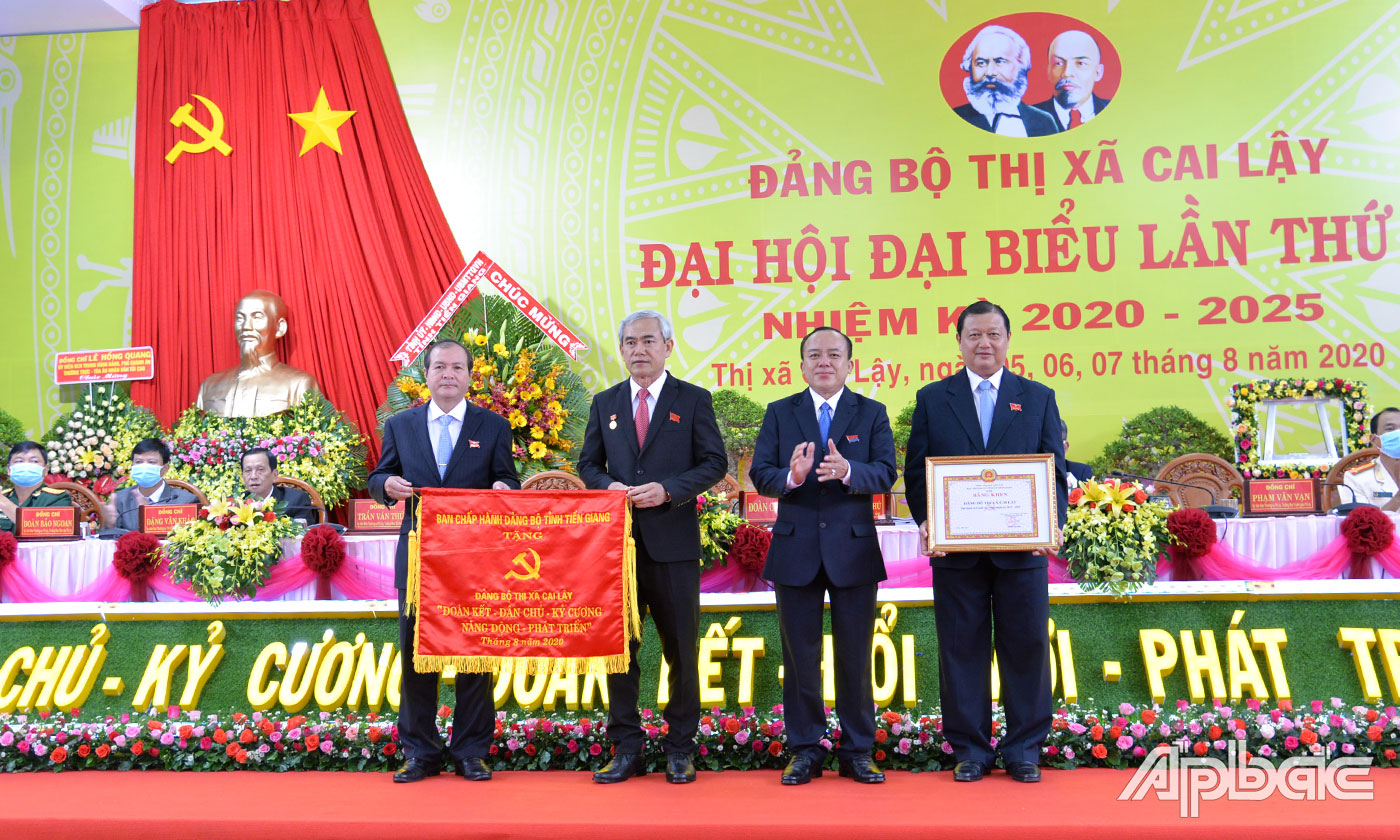 Đồng chí Nguyễn Chí Trung trao Bức trướng của Ban Chấp hành Đảng bộ tỉnh Tiền Giang và Bằng khen của Ban Thường vụ Tỉnh ủy tặng Ban Chấp hành Đảng bộ TX.