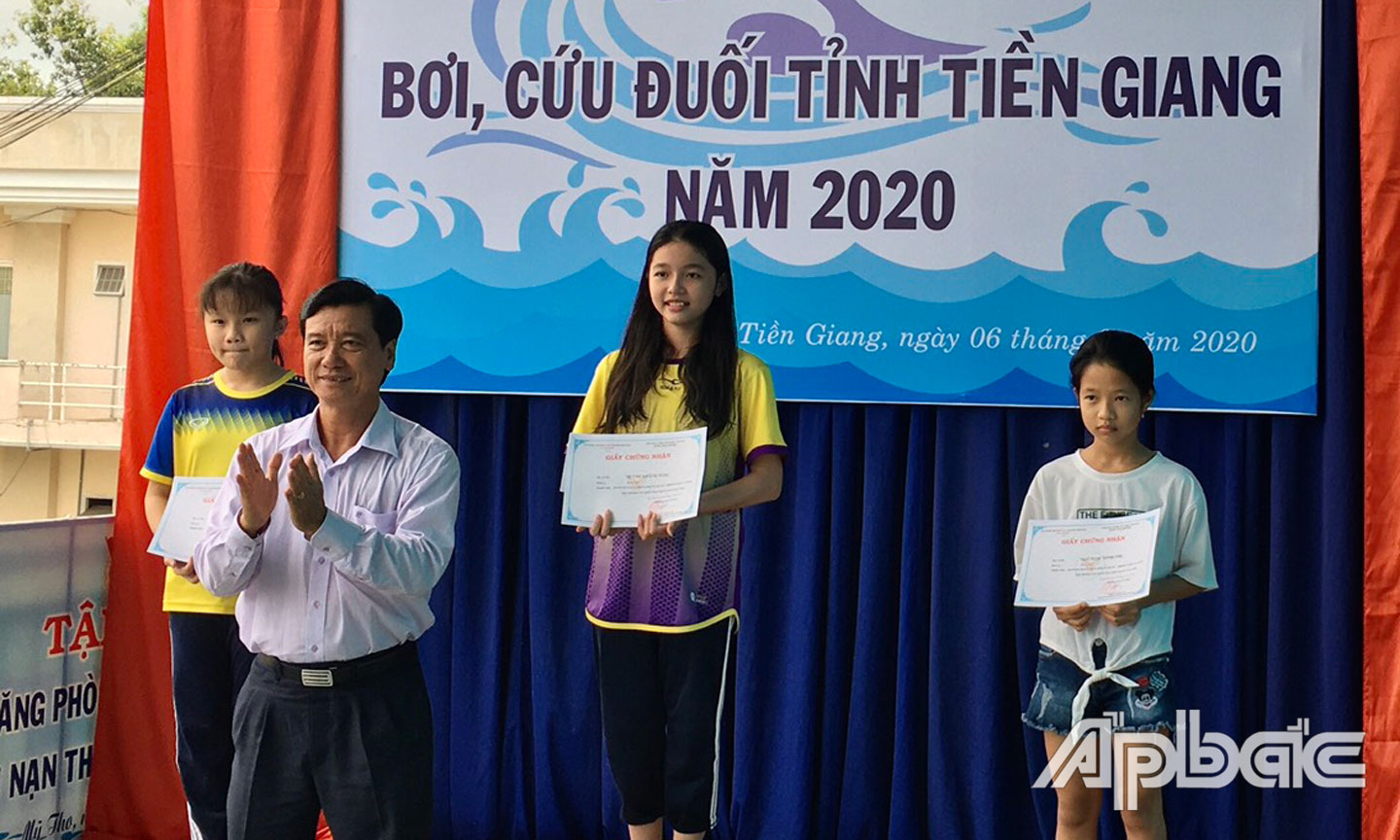 Ban tổ chức trao giấy chứng nhận cho các vận động viên đạt giải.
