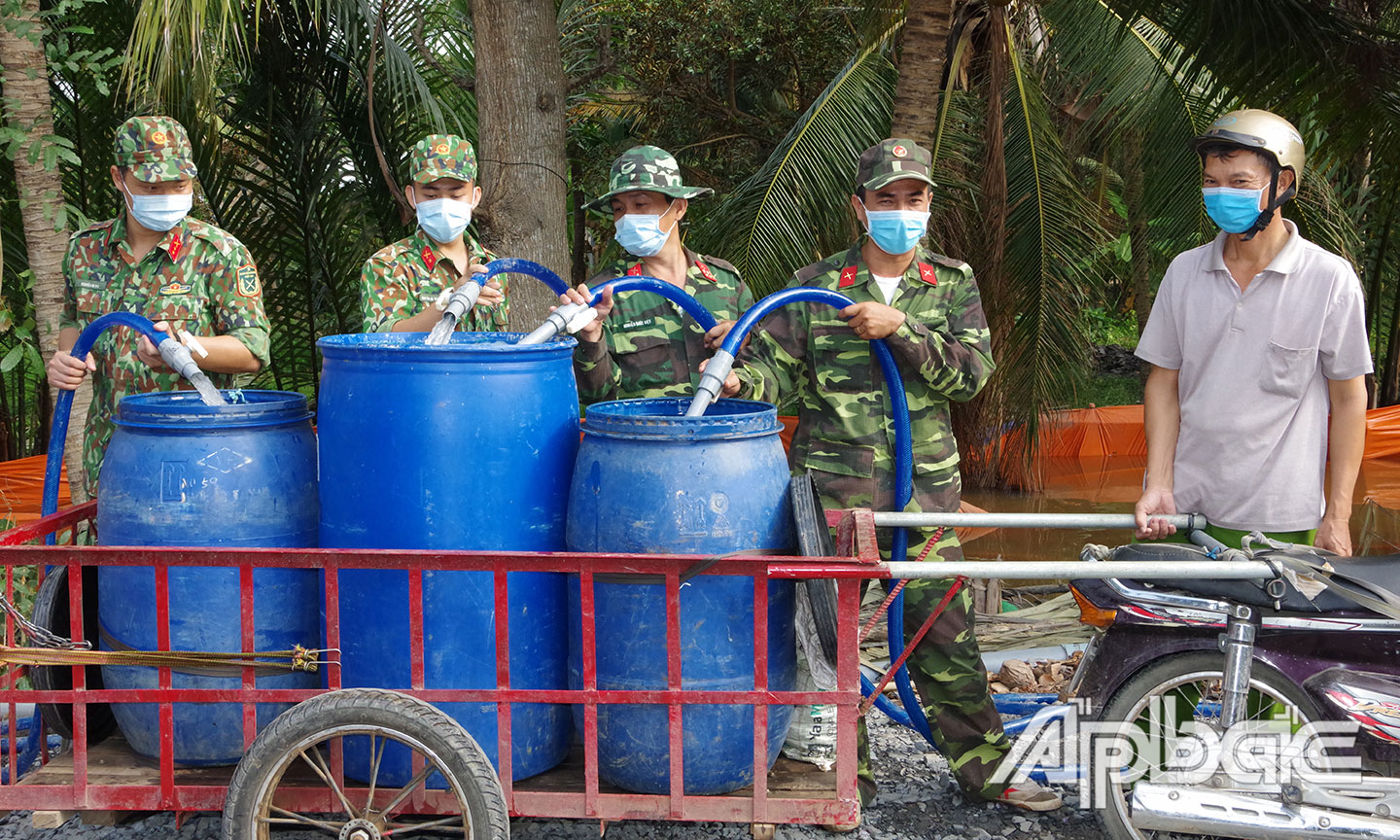 Cán bộ, chiến sĩ LLVT tỉnh chuyển nước ngọt phục vụ tưới tiêu cho người dân xã Mỹ Long, huyện Cai Lậy.  Ảnh: THANH LÂM