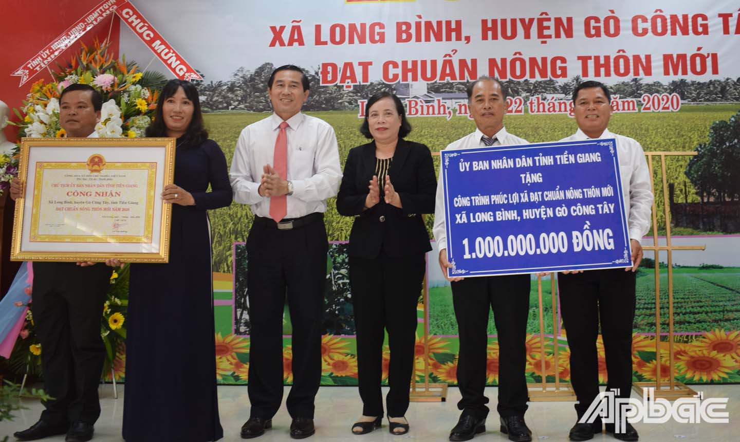 Đồng chí Lê Văn Hưởng và đồng chí Nguyễn Thị Đang trao tặng bằng công nhận đạt chuẩn NTM của UBND tỉnh và công trình phúc lợi 1 tỷ đồng cho UBND xã Long Bình. 