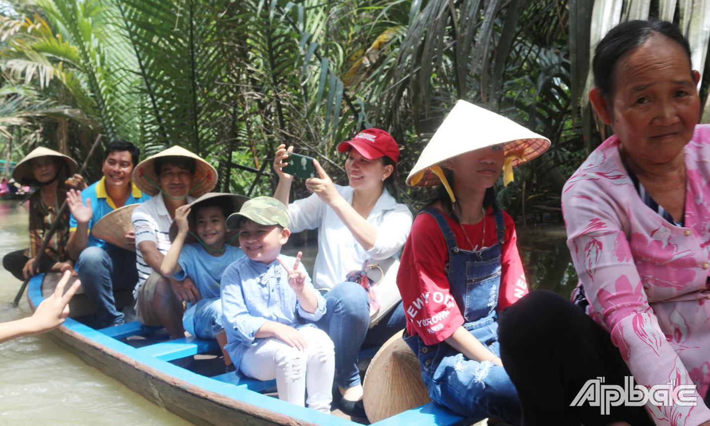 Khách du lịch “lướt sóng” cồn Thới Sơn bằng xuồng.
