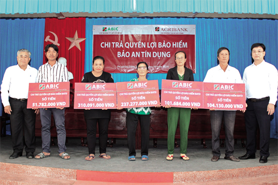 Đại diện ABIC và Agribank Tiền Giang trao Bảng tượng trưng chi trả quyền lợi bảo hiểm cho gia đình khách hàng.