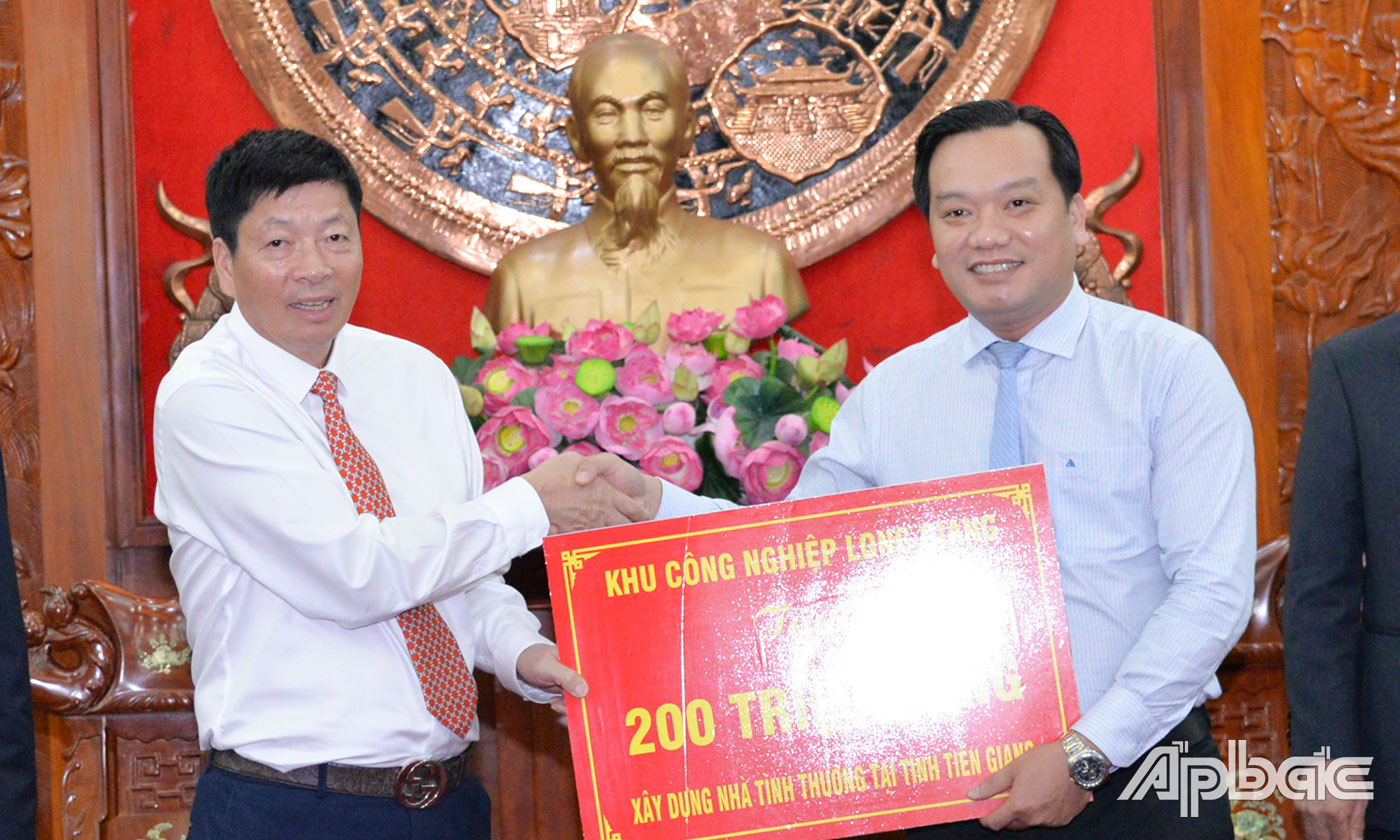 Dại diện Công ty TNHH Phát triển hạ tầng Khu Công nghiệp Long Giang trao bảng tượng trưng xây nhà tình thương cho tỉnh Tiền Giang.