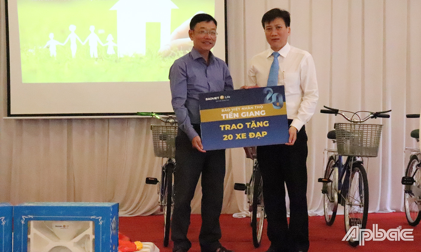Giám đốc Công ty Bảo Việt Nhân Thọ Tiền Giang Trần Phi Hùng trao bảng tượng trưng cho đại diện Phòng Lao động- Thương binh- Xã hội TP. Mỹ Tho.