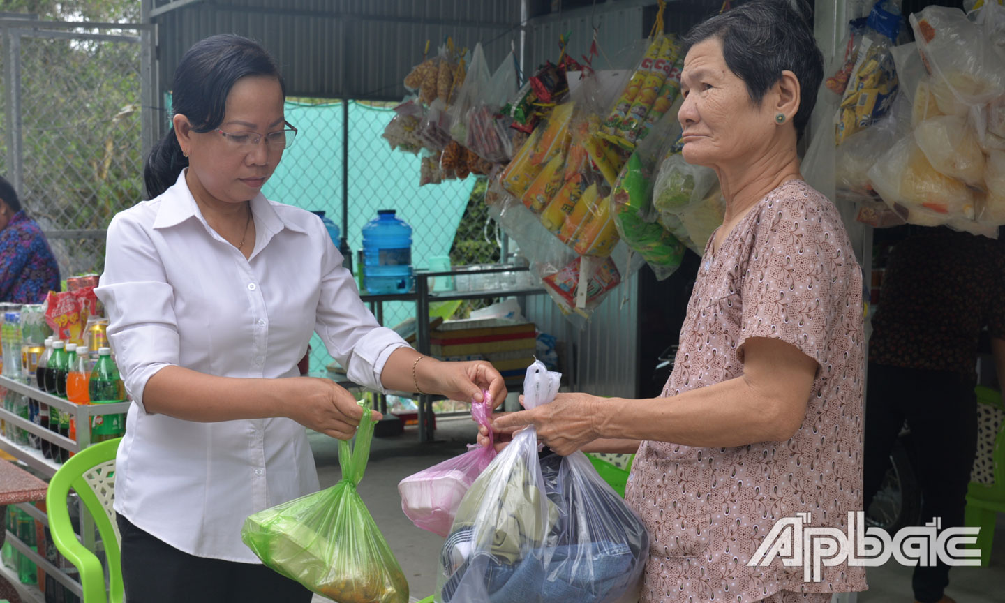 Chị Thủy trao cơm từ thiện cho phụ nữ có hoàn cảnh khó khăn của xã Tân Lập 2.