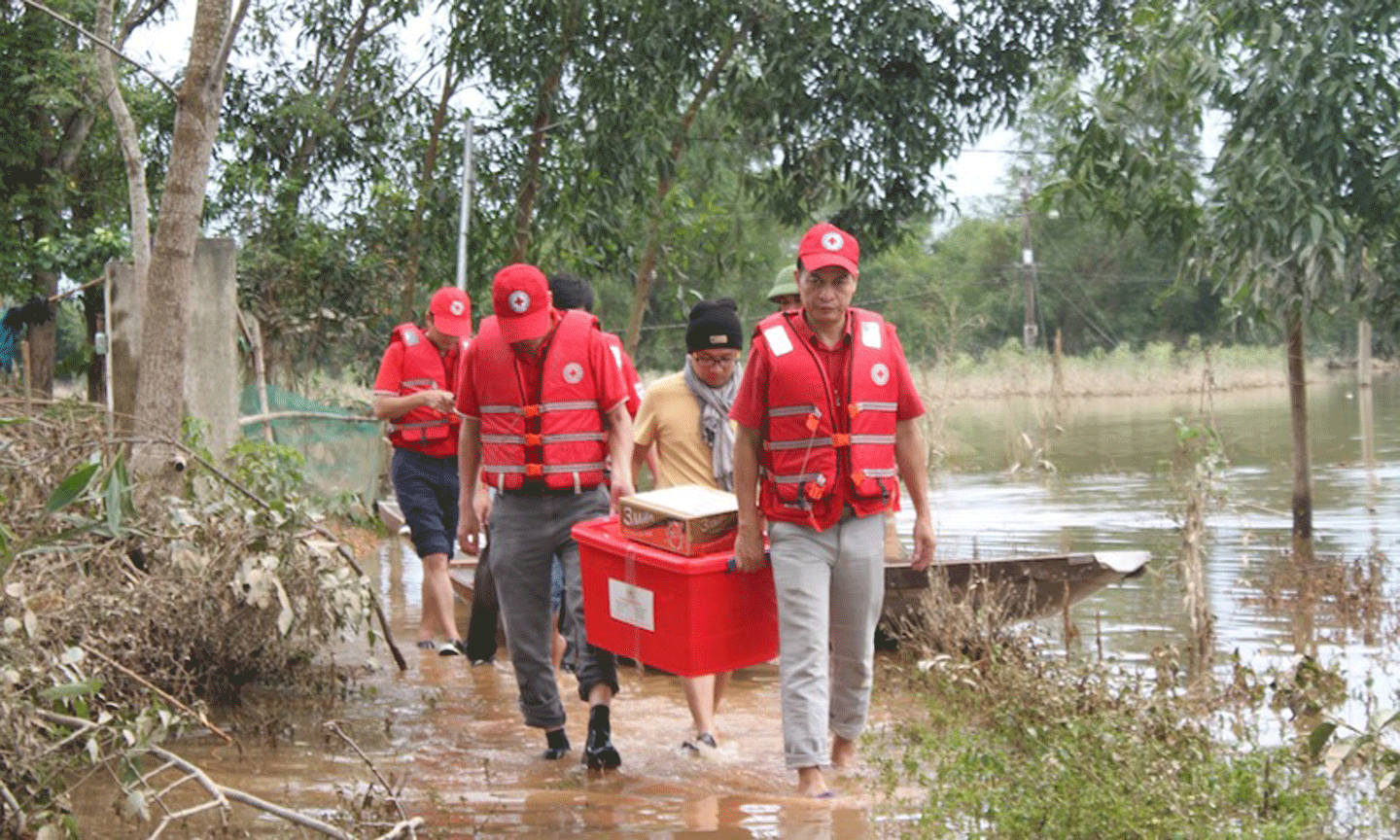 Ông Trần Quốc Hùng (ngoài cùng, bên phải) cùng đoàn cứu trợ của Trung ương Hội Chữ thập đỏ Việt Nam hỗ trợ bà con tại huyện Phong Điền, tỉnh Thừa Thiên Huế. 