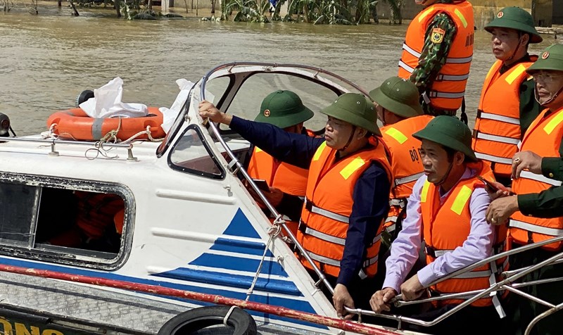 Bộ trưởng Nông nghiệp và Phát triển nông thôn, Phó Ban chỉ đạo TƯ về Phòng choogs thiên tai Nguyễn Xuân Cường đi cano kiểm tra vùng lũ Lệ Thủy, Quảng Bình ngày 22-10. Ảnh: HƯƠNG GIANG.