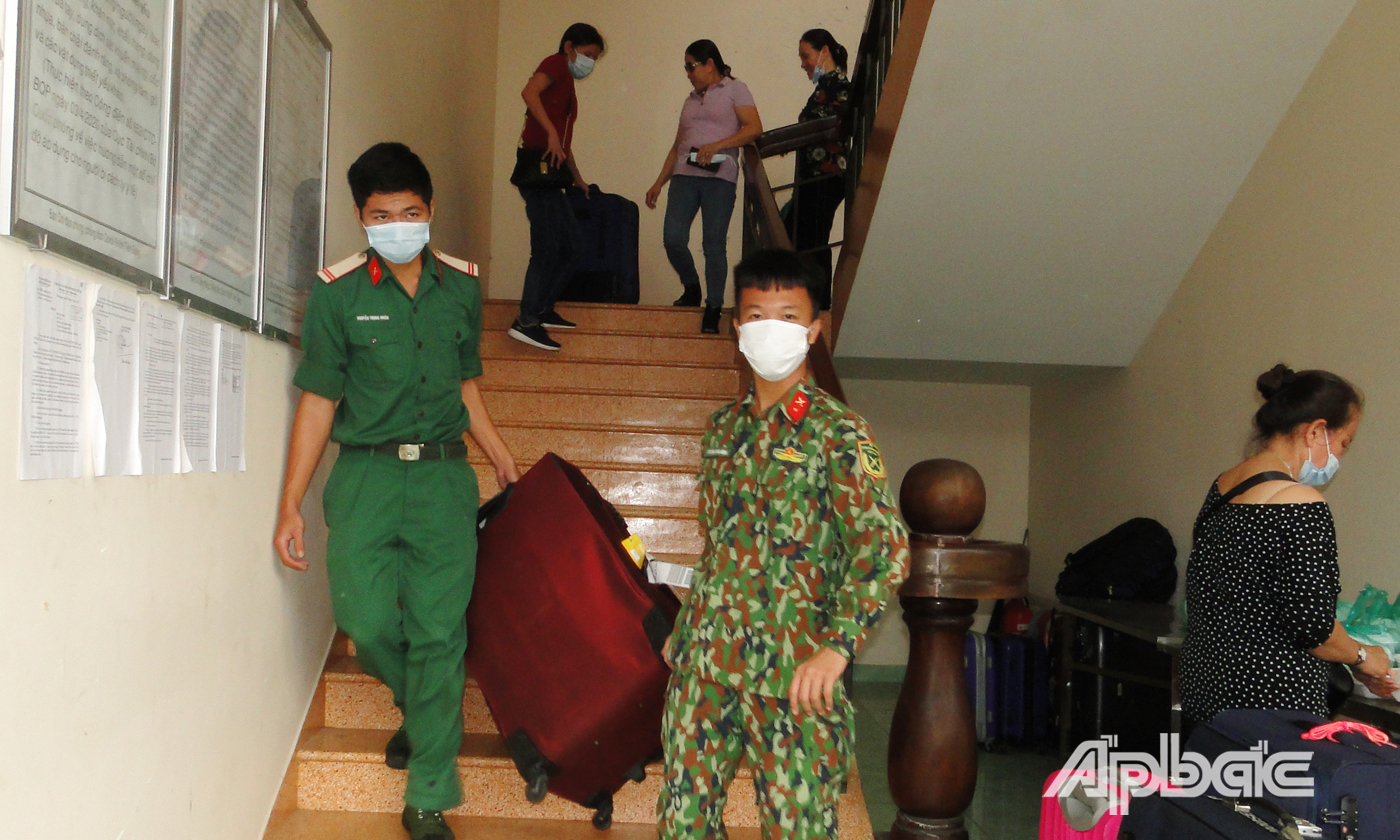 Chiến sĩ bộ đội hỗ trợ công dân vận chuyển hành lý ra xe rời khu cách ly