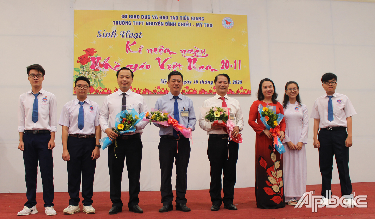 Các bạn học sinh tặng hoa tri ân các thầy cô Ban giám hiệu trường. 