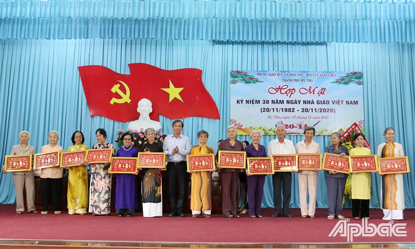 Phó Chủ tịch UBND TP Mỹ Tho Nguyễn Hữu Đức trao bảng chúc thọ cho thầy cô cao niên.