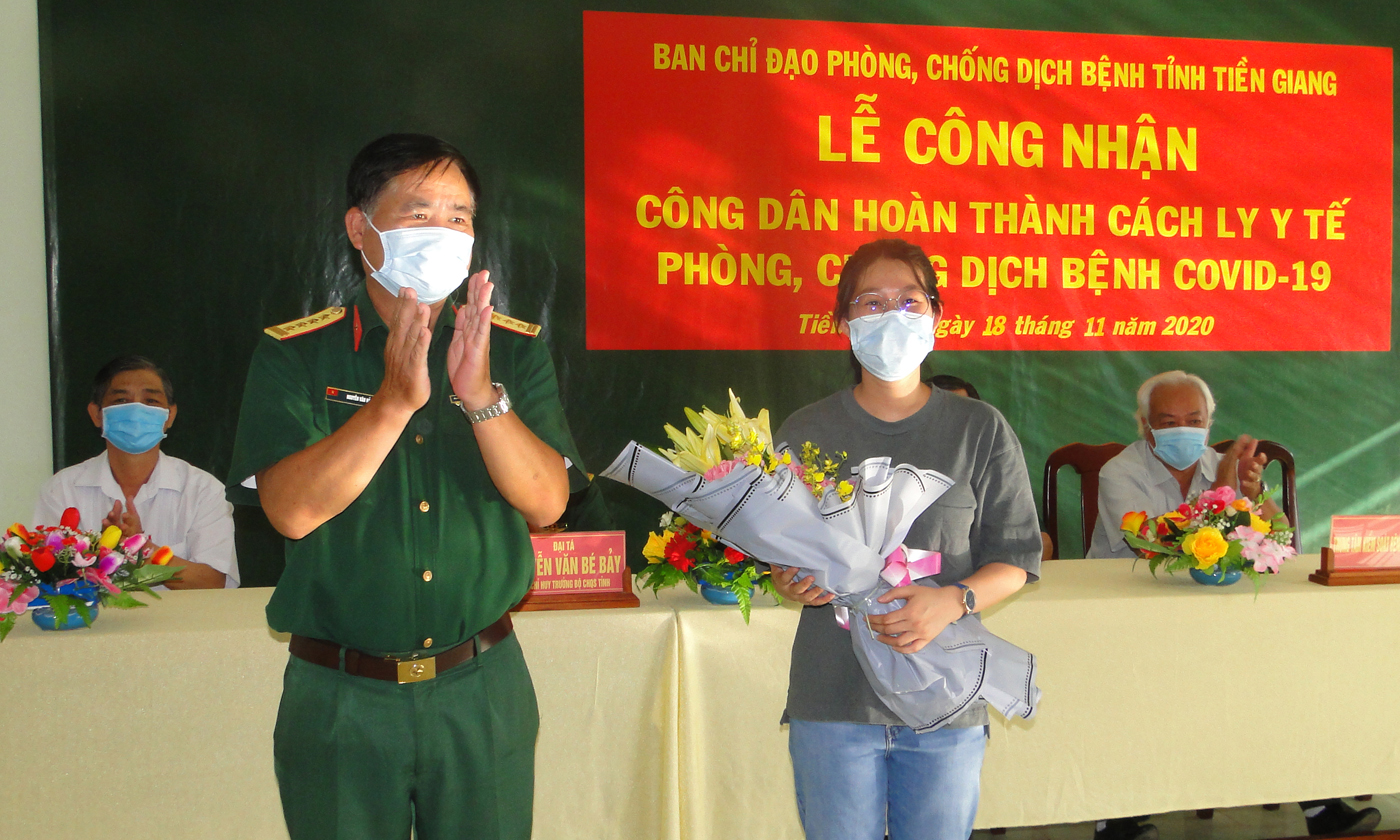 Đồng chí Nguyễn Văn Hải, đại diện ban quản lý khu cách ly trao hoa chúc mừng công dân